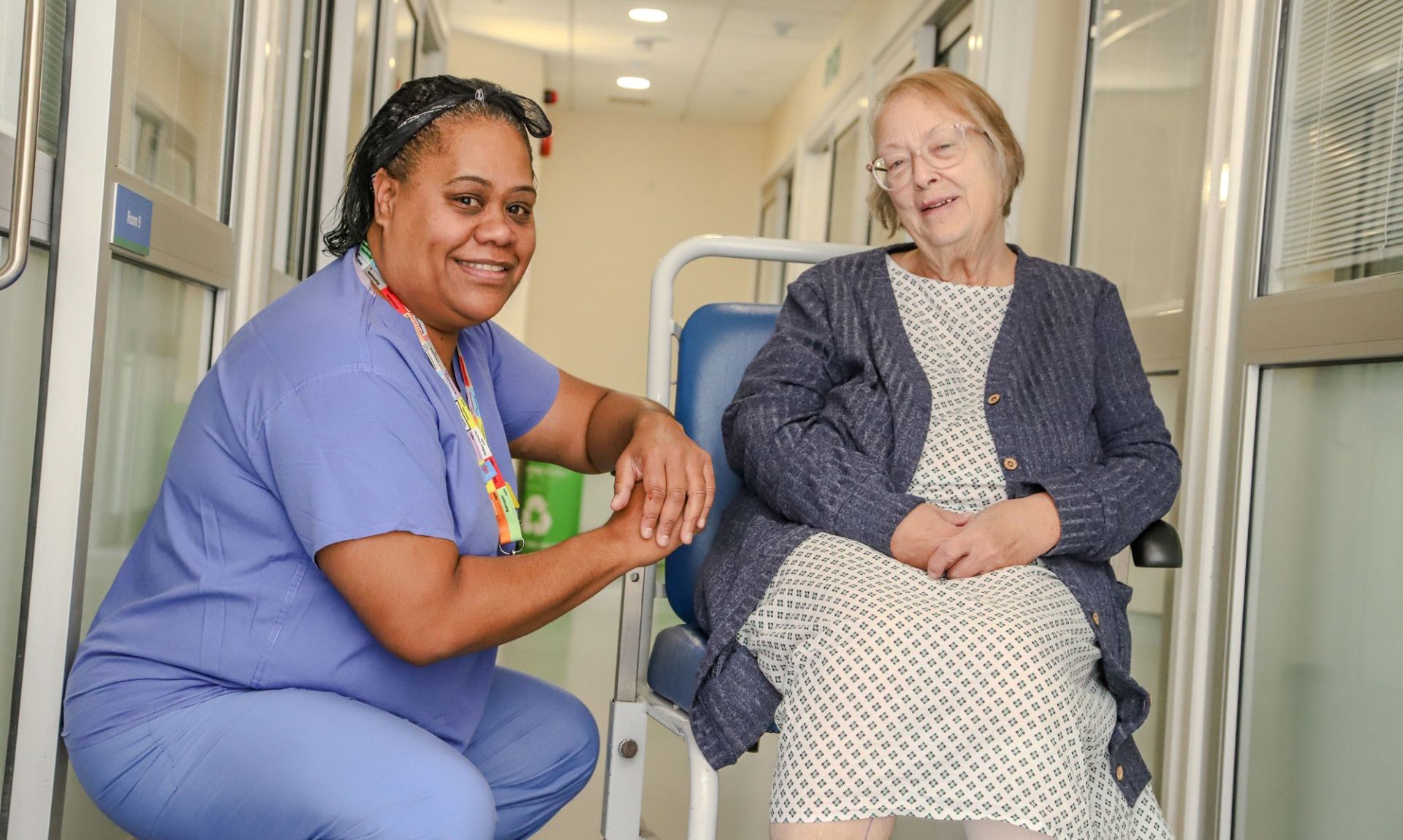 A Theatre Assistant Practitioner chats with a patient sitting in a wheelchair