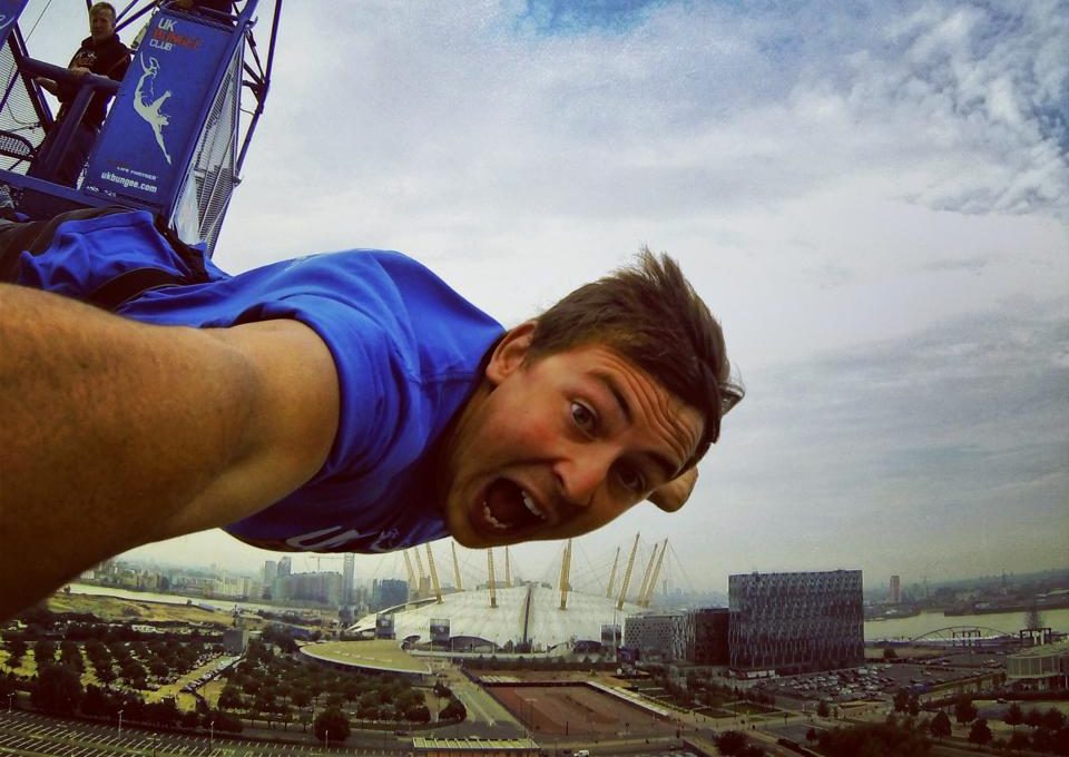 A person takes part in a bungee jump with the O2 Arena in the background