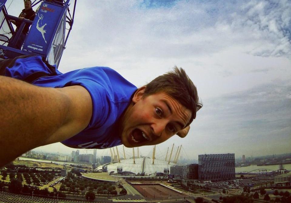 A person takes part in a bungee jump with the O2 Arena in the background