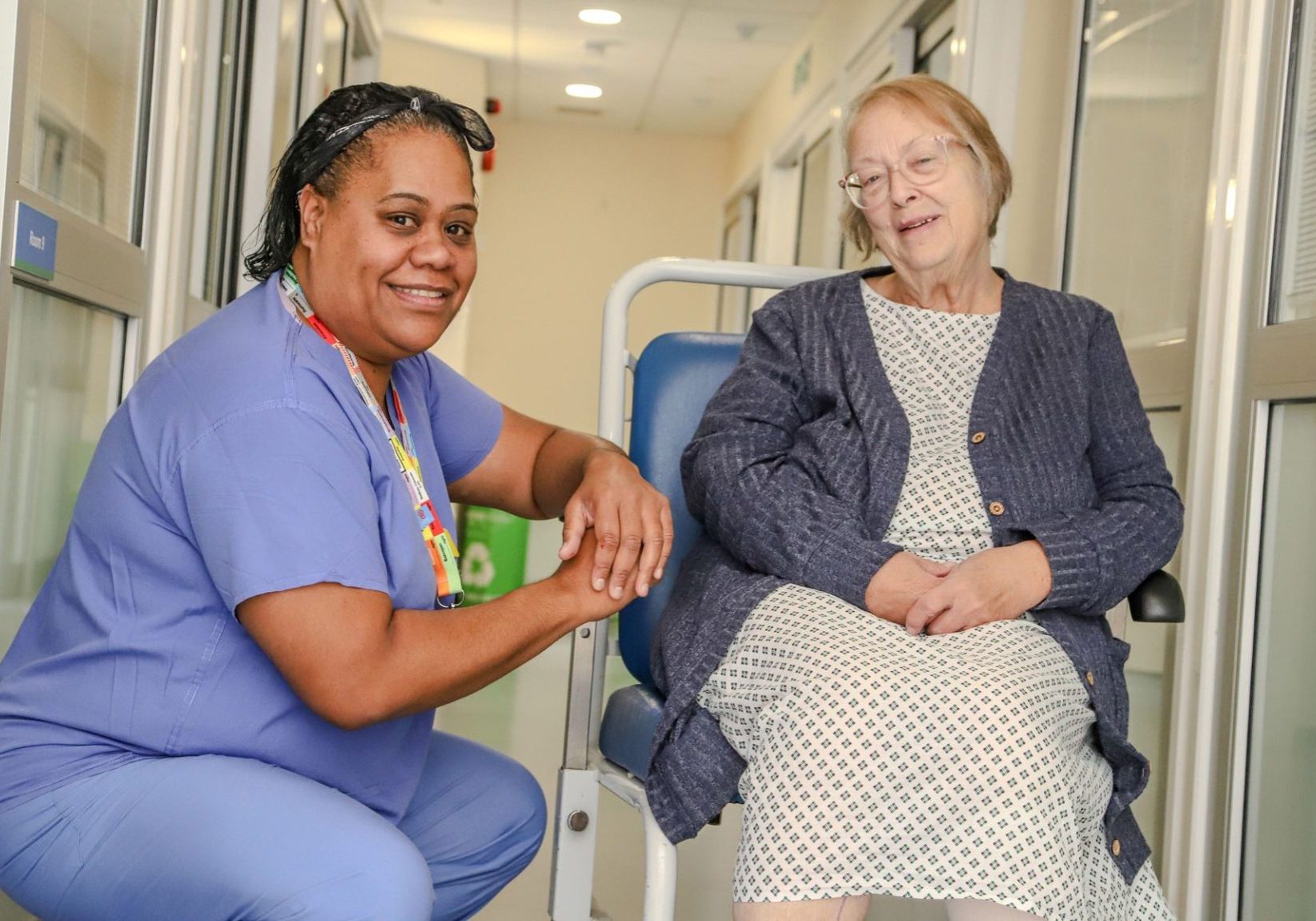 A Theatre Assistant Practitioner chats with a patient sitting in a wheelchair