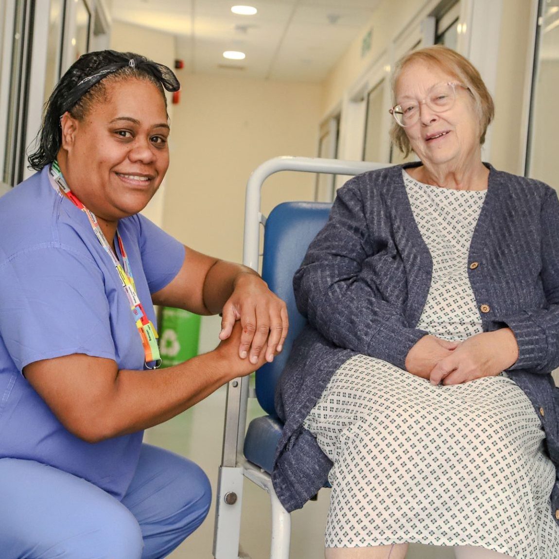 A Theatre Assistant Practitioner chats with a patient sitting in a wheelchair